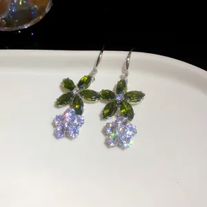 Detaillierte Nahaufnahme glitzernder Blumenohrringe mit grünen und weißen Zirkonia