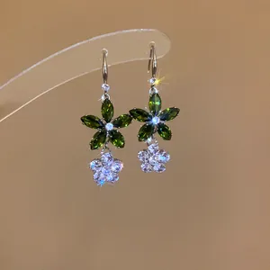 Detailansicht eleganter Blumen-Ohrhänger mit funkelnden grünen und weißen Zirkonia-Steinen