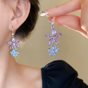 Detailansicht eleganter lila Zirkonia-Blumenohrringe mit funkelnden Blütenblatt-Details.