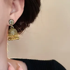 Orecchini a campana intagliati bohémien vintage mostrati sull'orecchio di modella