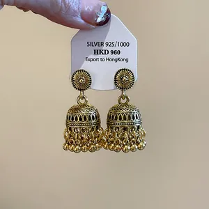 Vista dettagliata di orecchini jhumka vintage bohémien intagliati in oro con perline