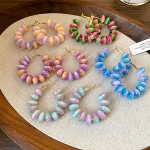 Macro collection of colorful resin bead hoop earrings with vibrant gradient tones