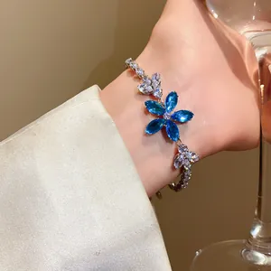 Nahaufnahme eines funkelnden blauen Zirkonia-Blumenarmbands an einem feinen Handgelenk