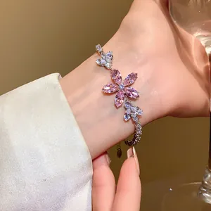 Nahaufnahme eines Armbands mit rosa Zirkonia-Blüten am Handgelenk mit Details