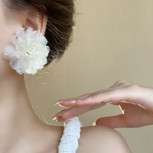 Primo piano di un elegante orecchino a fiore in rete bianca per un look romantico