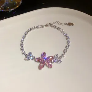 Nahaufnahme eines funkelnden rosa Zirkon-Blumenarmbands auf einem Teller