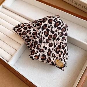 Close-up of a leopard print fabric hair clip inside a white jewelry display tray.