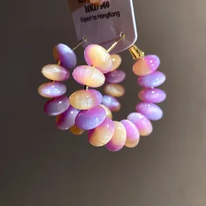 Close-up of colorful gradient resin bead hoop earrings with silver needles