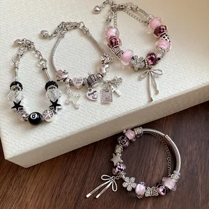 Close-up detail view of four sweet charm bracelets with glass beads, flowers and bows.