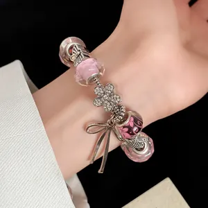 Close-up detail of sweet beaded bracelet with pink glass charms and flower pendant