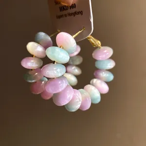 Close-up of pastel resin beaded hoop earrings with iridescent pearly finish