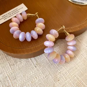 Detailed shot of round hoop earrings with sweet pastel gradient resin beads
