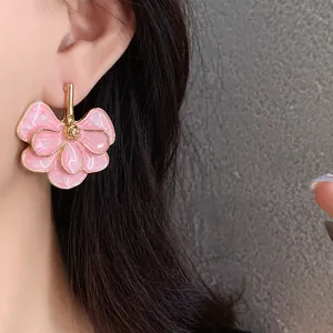 Close-up of pink ginkgo leaf flower earrings with gold trim and silver needles
