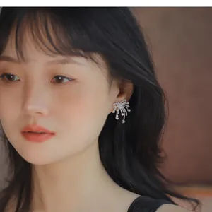 Elegant silver firework stud earrings with zircon and pearls on Asian female model