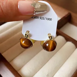 Vintage-Ohrringe mit rundem Tigerauge-Stein in Goldoptik und 925er Silberstempel.