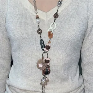 Close-up detail of Bohemian style necklace with woven flowers, beads and pearls on model.