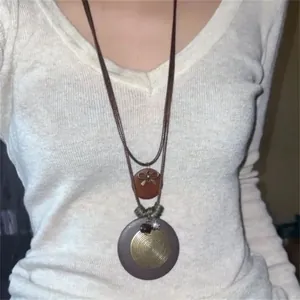 Close-up detail of bohemian ethnic style pendant necklace worn by female model