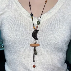 Detail view of the Bohemian ethnic style necklace with moon charm and beads worn on a model