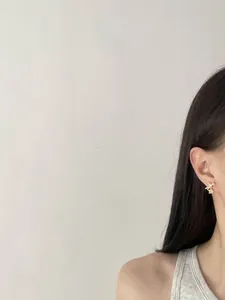 Detailed side view of a model wearing elegant zircon bow and star stud earrings