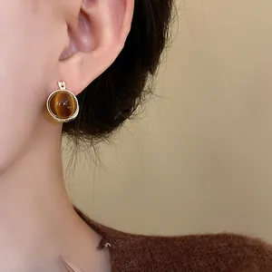 Nahaufnahme von runden Vintage-Creolen mit einem braunen Tigerauge-Stein im Detail