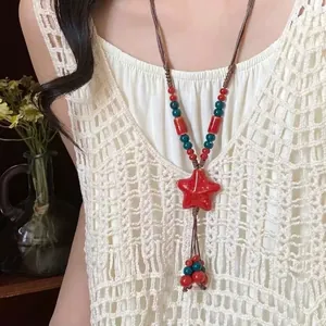 Detailed close-up of a Bohemian ethnic woven necklace featuring a vibrant red star pendant