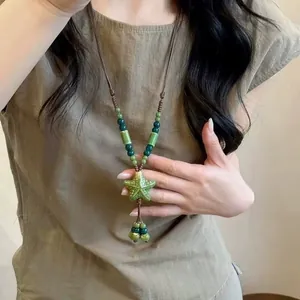 Detailed view of bohemian ethnic braided necklace with green star pendant