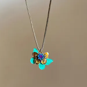 Detailed view of bohemian butterfly pendant with teal enamel and colorful rhinestones