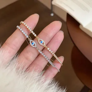 Dettaglio di bracciali occhio del male in oro e argento con zirconi luccicanti