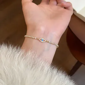 Dettaglio di un bracciale vintage dorato con un occhio greco e zirconi scintillanti