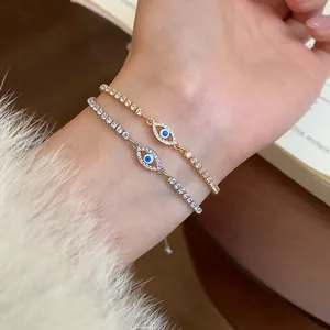 Primo piano dettagliato di braccialetti occhio del male in oro e argento con zirconi al polso.