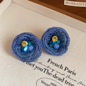 Detaillierte Makroansicht gewebter blauer Blumenstecker mit bunten Kristallzentren