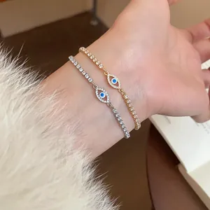 Dettaglio di eleganti braccialetti occhio greco in oro e argento con zirconi al polso