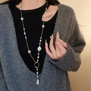 Detailed close-up of a vintage irregular faux pearl sweater chain necklace on a model