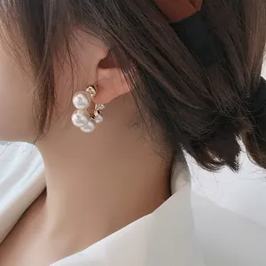 Elegant cluster pearl hoop earrings featured on a model for a chic and stylish look