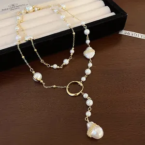 Close-up of a vintage irregular faux pearl pendant necklace with gold chain details.
