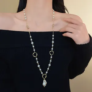 Close-up of irregular pearl pendant necklace worn as a vintage sweater chain