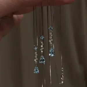 Silver necklace with blue teardrop gemstone pendants and shiny diamond accents.