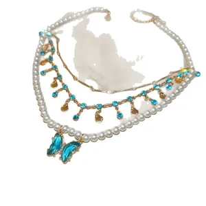 Elegant double-layered pearl necklace with blue butterfly pendant and gold shell tassels