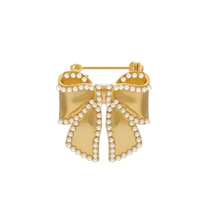 Elegant vintage golden bow brooch featuring delicate pearl edge embellishments for coats