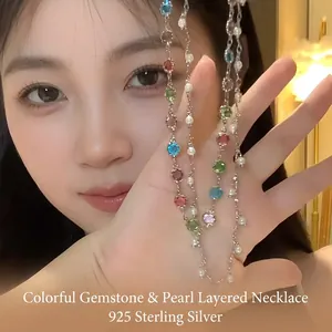 Detail view of an elegant double-layered necklace with colorful gems and white pearls