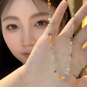 Detailed view of a colorful crystal bead necklace held by a female model.