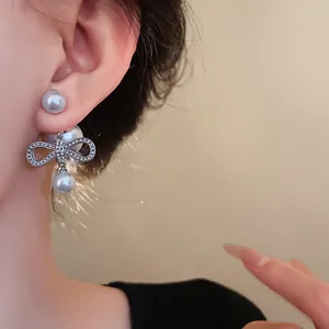 Primo piano di eleganti orecchini a fiocco con perle finte sull'orecchio di una modella