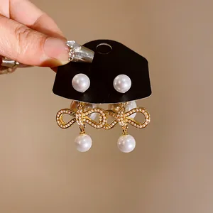 Orecchini a fiocco placcati in oro con perle artificiali bianche, stile versatile.