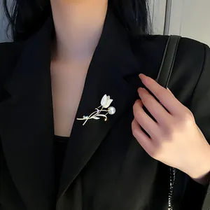 Detail view of an elegant tulip pearl brooch with crystals on a black suit jacket lapel