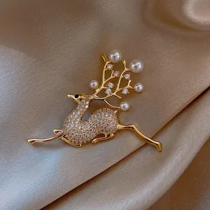 Detailed view of a vintage golden reindeer brooch with pearls and sparkling crystals