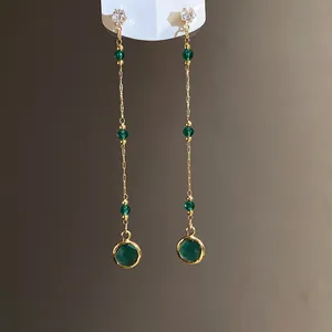 Nahaufnahme des eleganten grünen Glasanhängers an der goldenen Kette im Vintage-Stil