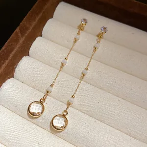 Nahaufnahme von runden Glasquasten-Ohrringen im Vintage-Stil mit vergoldeten Ketten
