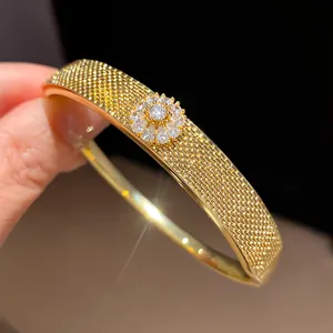 Detailed view of 18k gold plated bangle with sparkling zircon flower centerpiece