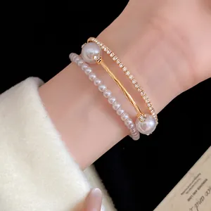 Close-up of elegant triple-layer open bangle bracelet with pearls and sparkling rhinestones