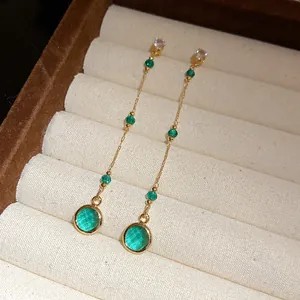 Detailansicht von vintage smaragdgrünen Glaskreis-Quastenohrringen in einer Schmuckschatulle